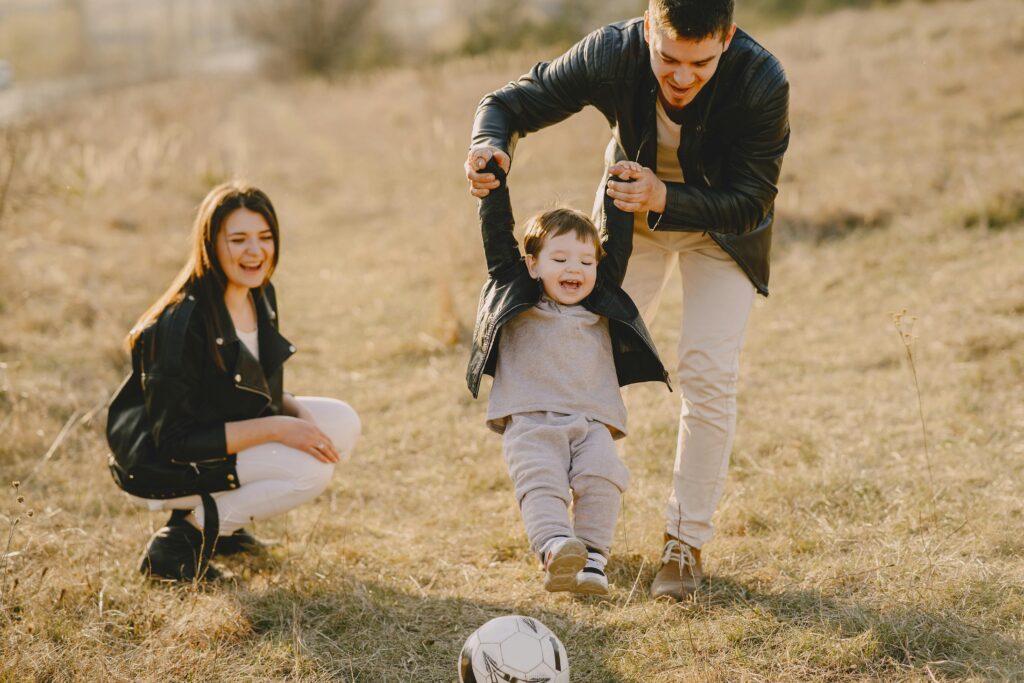 Family enjoying playful soccer game outdoors, capturing joyful moments highlighting the importance of safety for family.